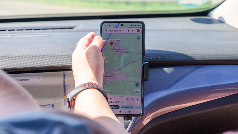 A person interacting with the Google Maps app during navigation.