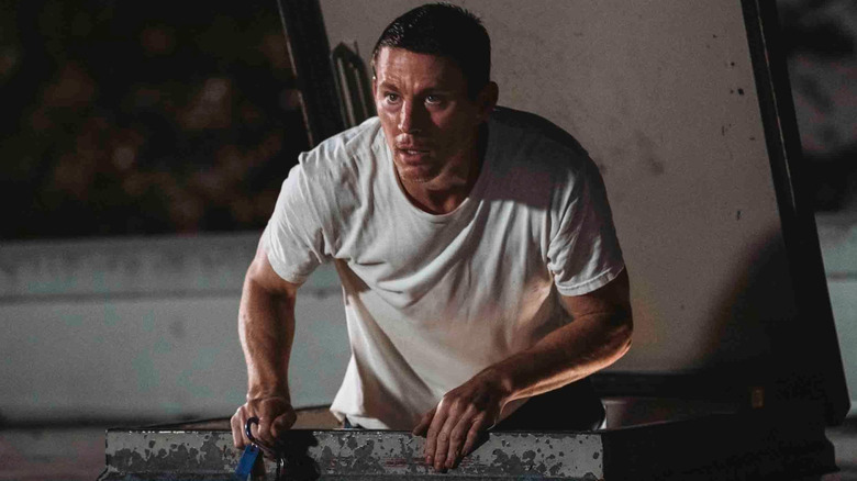 Channing Tatum in Roofman while climbing up onto a store's roof.