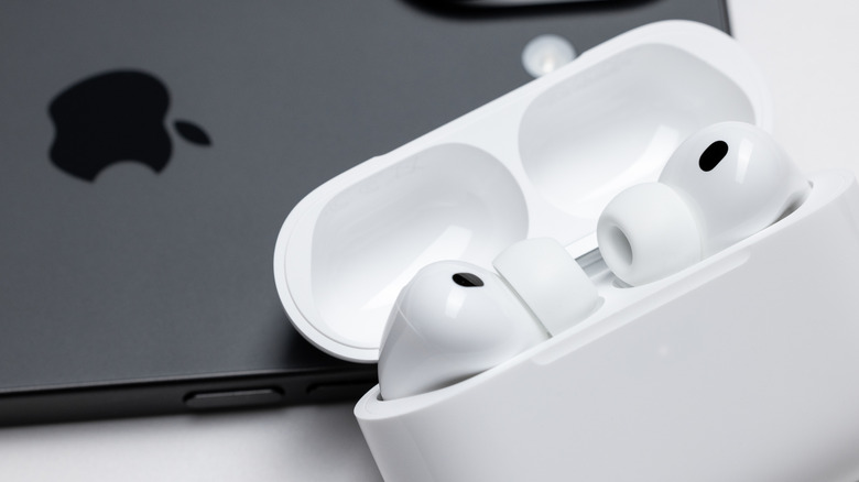 AirPods sitting on a table in their case on top of an iPhone