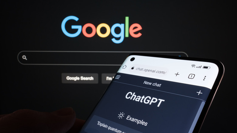 ChatGPT on a smartphone with Google open on a computer in the background
