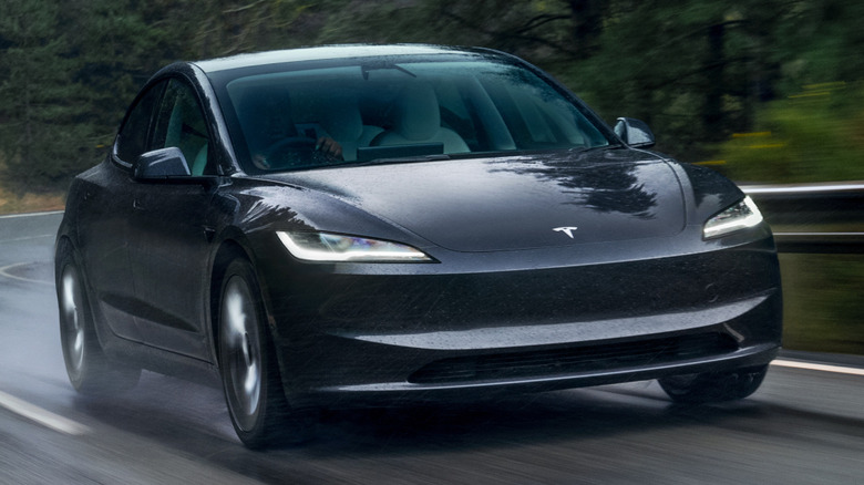 A Tesla Model 3 driving on the road
