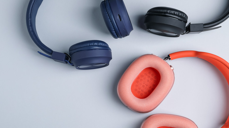 A black, blue and orange pair of headphones on a pale background.