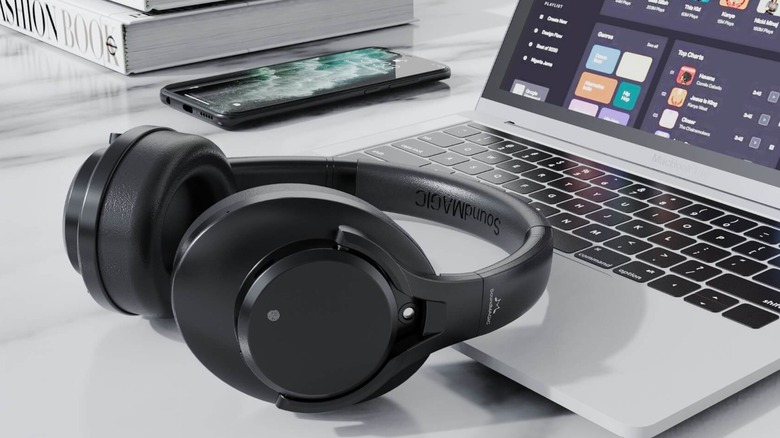 A pair of Soundmagic headphones, resting on a laptop.