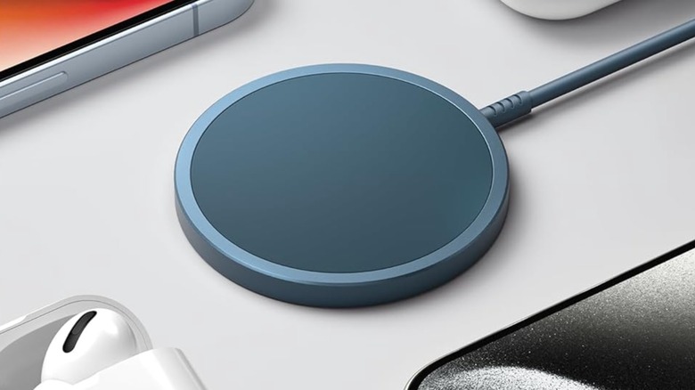 A closeup of the black Jsaux 15 W MagSafe Wireless Charger, the charger is surrounded by various Apple products