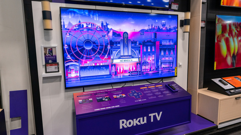 Roku TV display in a retail store with the logo and screensaver on show.