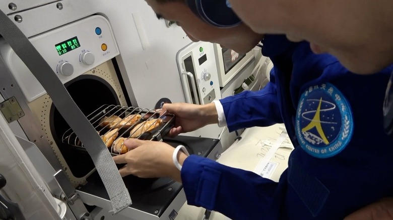 Astronauts place chicken into their newly acquired Zero-G space oven.