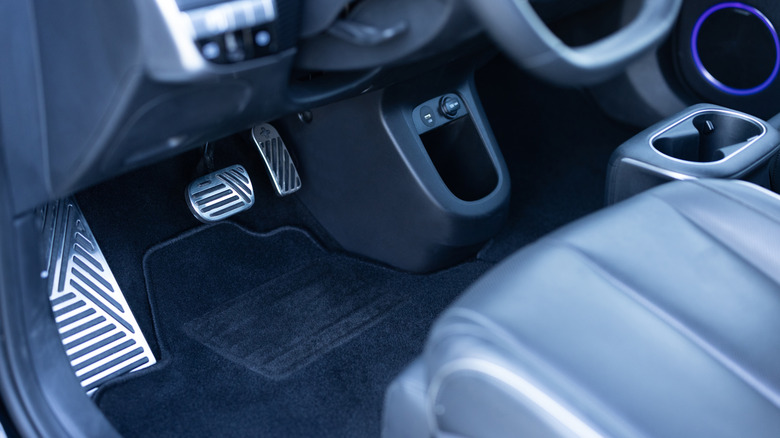 accelerator, brake, and dead pedal in dark car interior