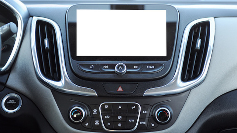 A car's infotainment system with physical buttons and a touchscreen.