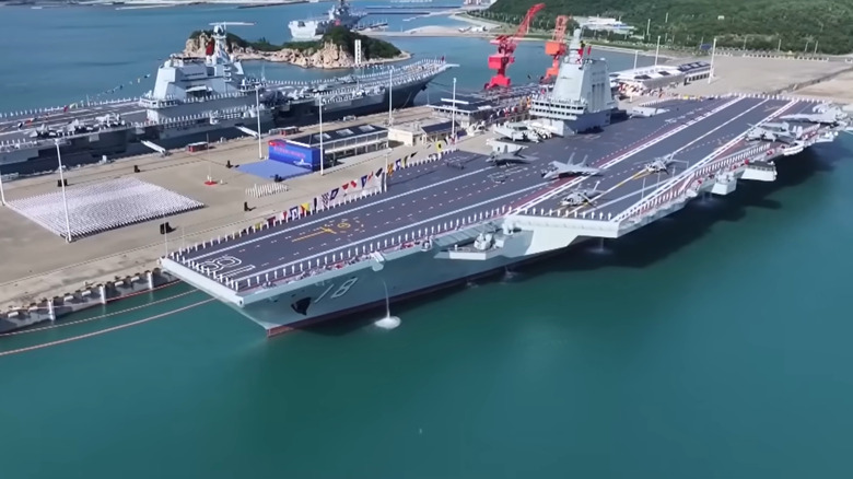 China's aircraft carrier, the Fujian, docked at port beside its predecessor, the Shandong, at the start of its commissioning ceremony.