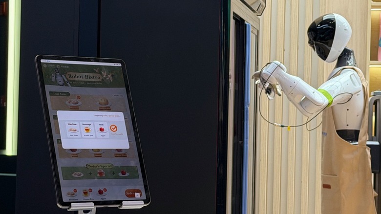 A tablet where you can order food with a humanoid robot opening a fridge