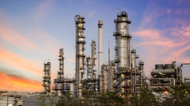 Gas and oil refinery station against a sunset sky