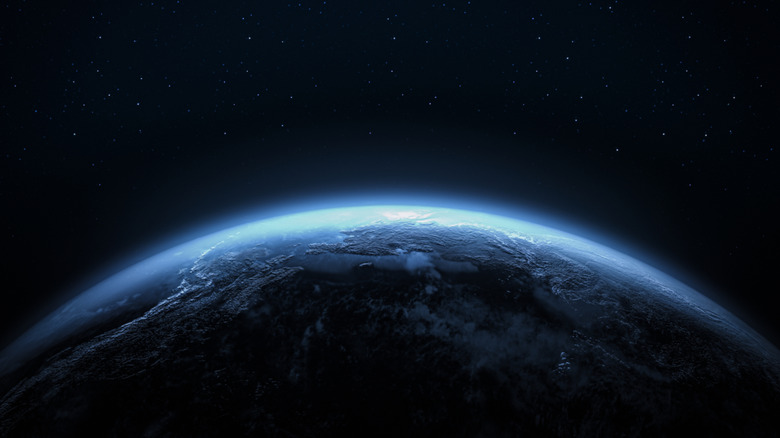 A rendering of planet Earth with a view of a glowing blue horizon set against a starry sky.