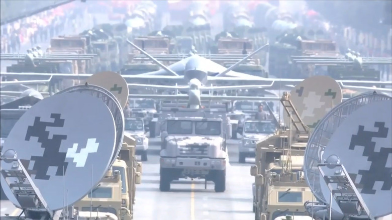 Drones are shown mounted on truck beds during a military parade in China.