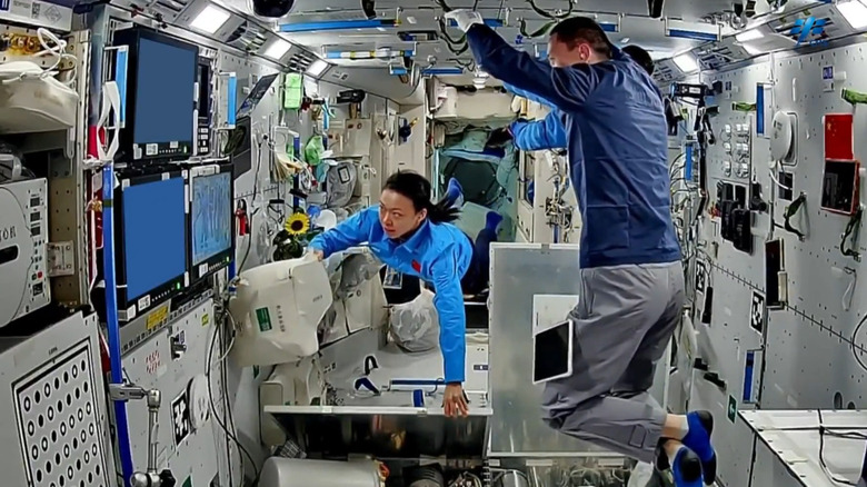 Taikonauts seen operating in the Tiangong space station in low Earth orbit