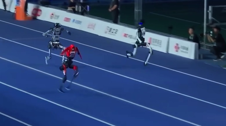 Three humanoid robots racing at the World Humanoid Robot Games in China.