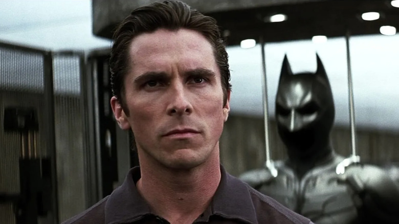 Image of Christian Bale in front of the batsuit