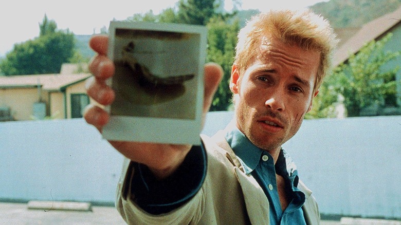 Still image of Guy Pearce holding up a Polaroid from 
