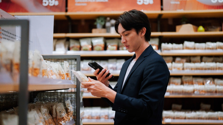Man using a phone on a supermarket