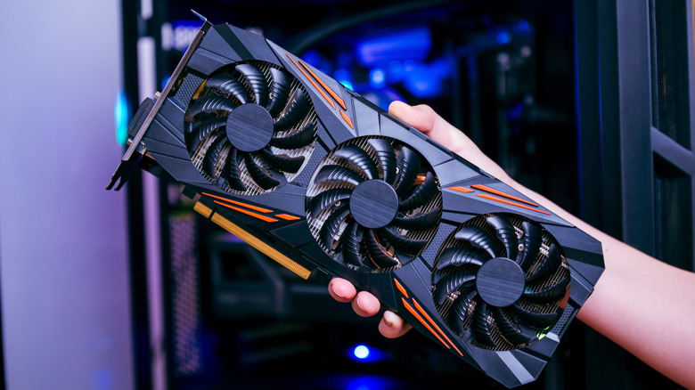 A hand holding a GPU