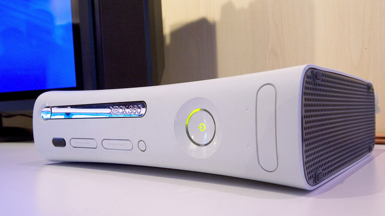 An Xbox 360 on a table, with a TV in the background