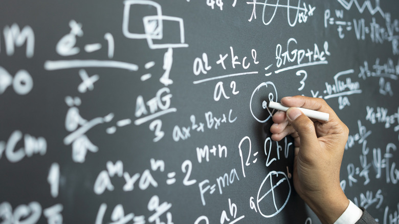 professor writing equations on a chalkboard