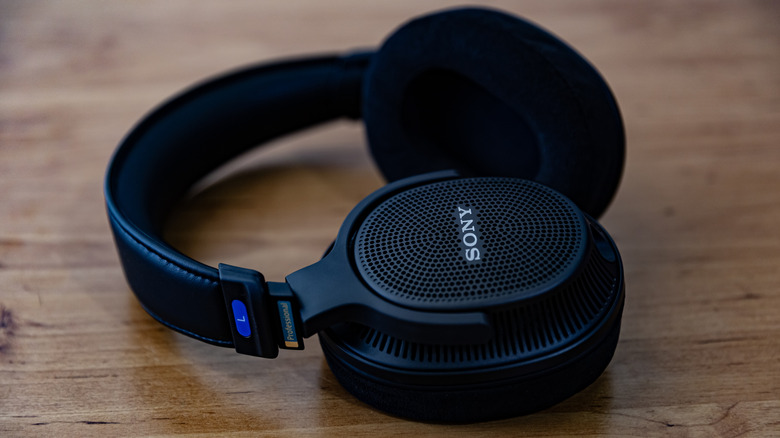 A pair of black open-back Sony headphones on a table.