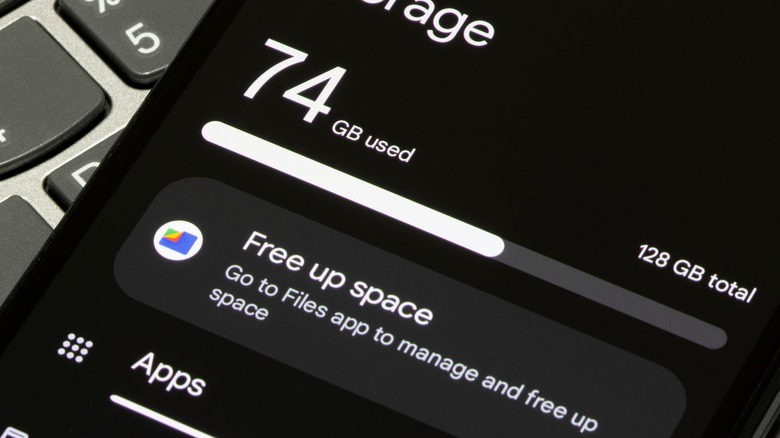 A phone displaying the Free up space option for Google Files placed on a laptop keyboard