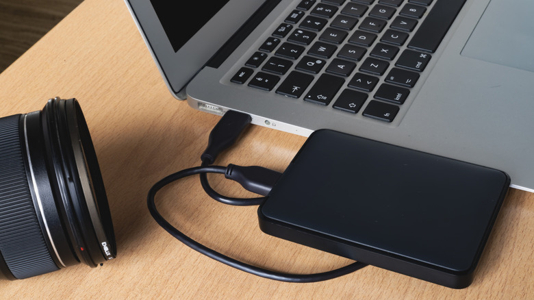 Generic black external hard drive plugged into laptop