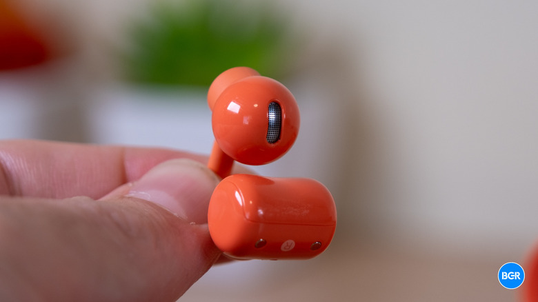 Holding a CMF Clip Pro earbud