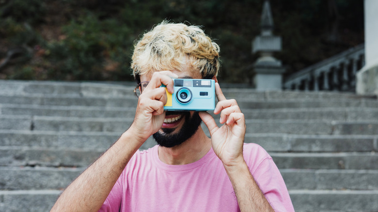 Man shooting photos with a point-and-shoot camera
