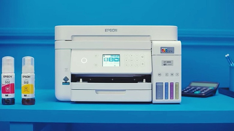 An Epson EcoTank ET-3850 printer with ink bottles nearby.