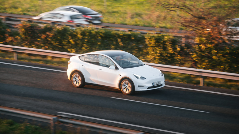 Tesla Model Y driving on a highway with cars in the background