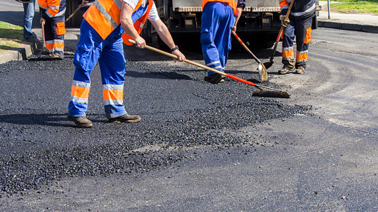 people paving a road