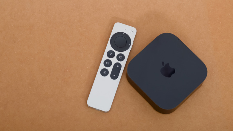 Apple TV 4K and its remote on a wooden table