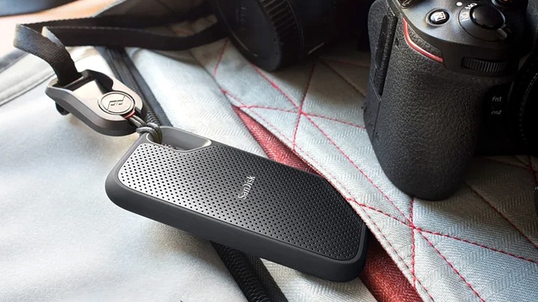 Sandisk portable storage drive clipped to a camera bag