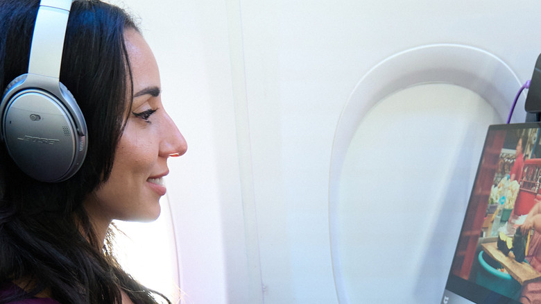A woman on a plane watching TV on an espresso Portable Monitor.