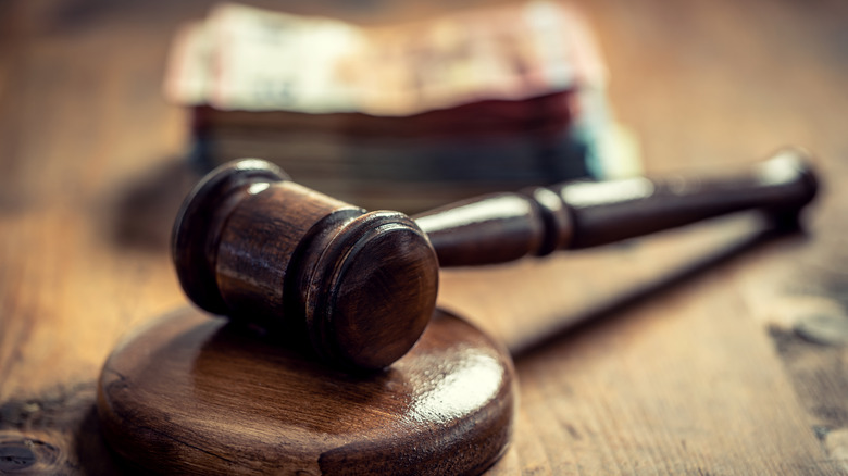 a court legal gavel on a wooden table with money in the background