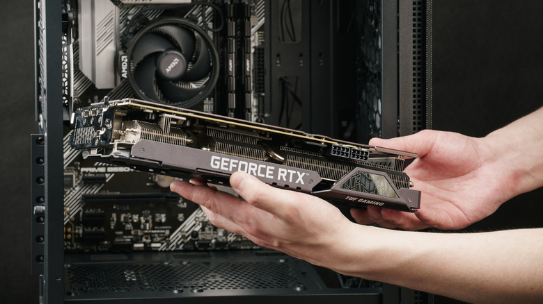 Person placing a graphics card into their PC