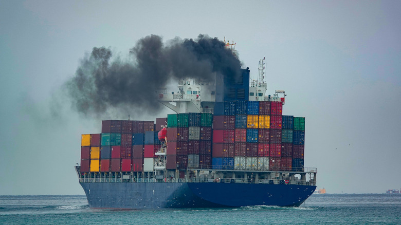 A freight ship at sea producing high-pollutant emissions