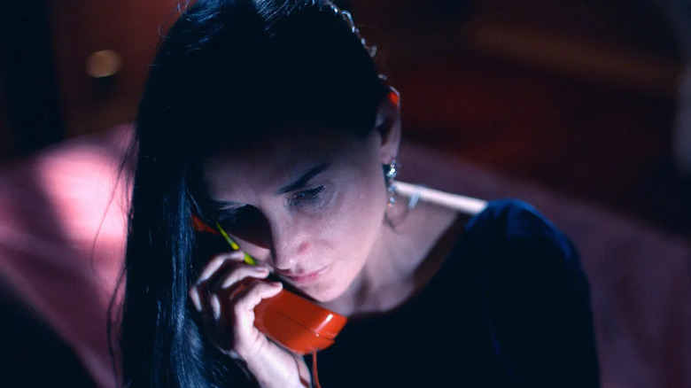 Elisabeth (Demi Moore) holding a phone receiver against her ear in "The Substance."