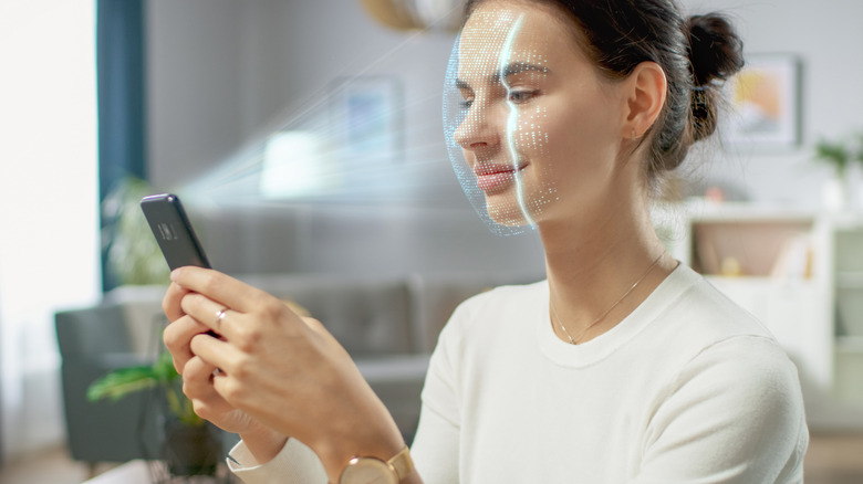 woman completing facial scan using smartphone