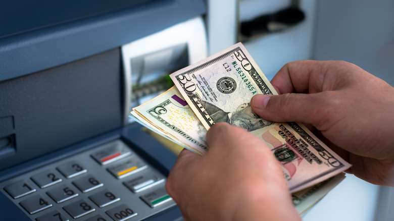 a person getting money from an ATM