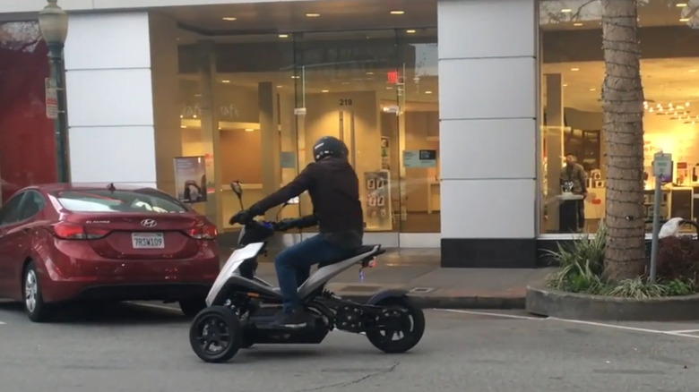 The Sway Motorsports scooter being driven outside of a retail strip