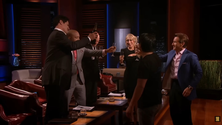 Shark Tank judges and Charles Yim toasting to the Breathometer deal