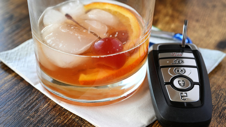 A glass of alcohol next to car keys