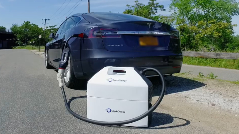 a SparkCharge EV charger charging a Tesla