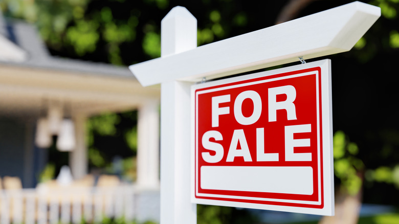 A real estate for-sale sign outside of a house