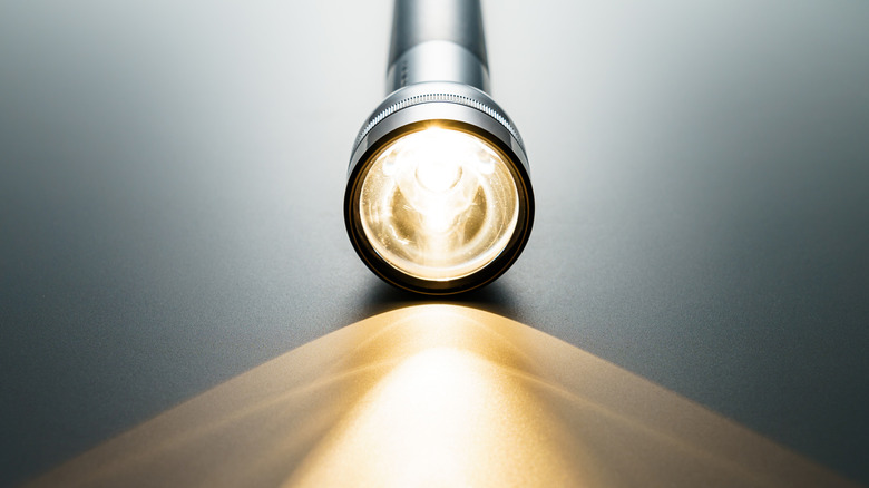 Illuminated flashlight on a table