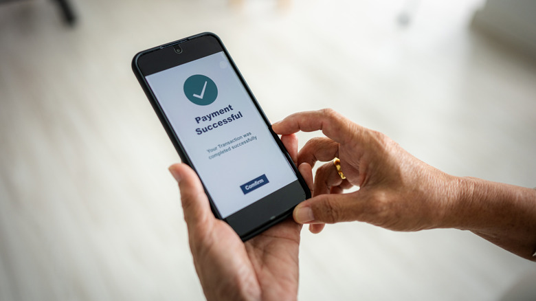 Person confirming a digital payment on a smartphone