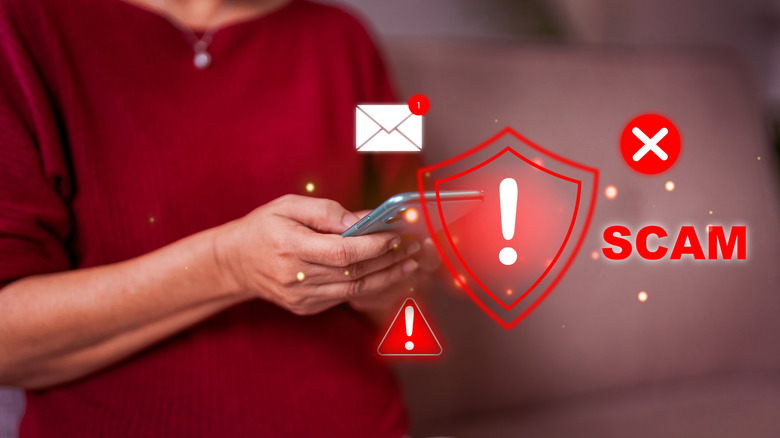 Person holding a smartphone with warning icons and the word 